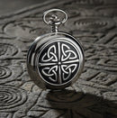 Silver pocket watch with Celtic knot design on a white background