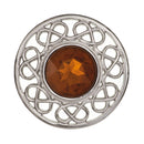 Stroma Brooch styled on a fabric surface, illustrating its vibrant stone and meticulous attention to detail.