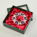 Silver brooch with blue gemstones in a black box with red satin lining